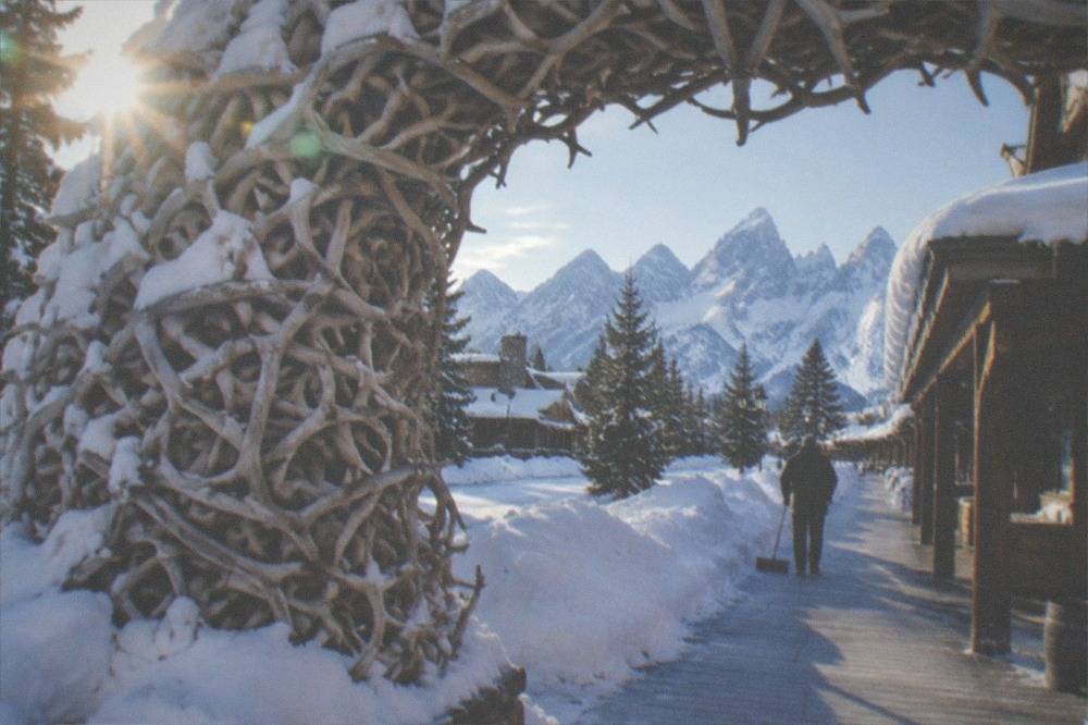 A western town square with elk antler arches and snow piled along the boardwalks